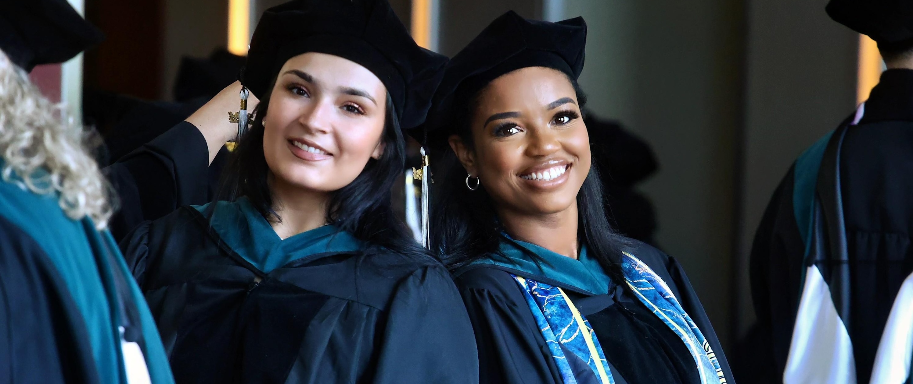 Two graduates smiling during Commencement